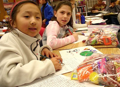Here, students write letter and draw pictures to be sent with the candy.