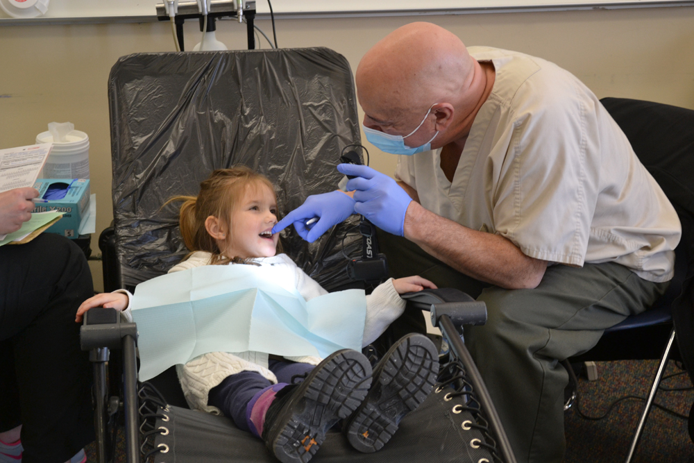 Dentist Michael Swedo counts a student's teeth at the Ann Arbor Preschool and Family Center Feb. 10, 2014.