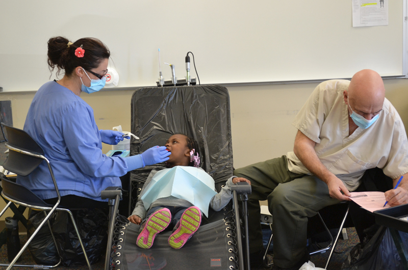 Dentist Michael Swedo and hygienist Grace Peruski provide an examination and cleaning Feb. 10, 2014.