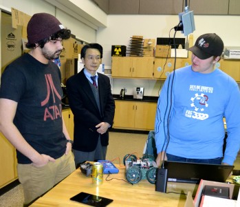 Seniors Ben Halligan, left, and Kevin O'Brien talk robotics with IMRA's Kazuo Ishikawa.
