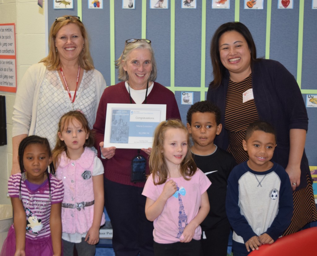 Allen Principal Kerry Beal, kindergarten teacher Marie Lemmer, some of her students, and the Ann Arbor Public Schools Educational Foundation Executive Director Linh Song celebrating the renewal of a grant to provide in-coming Allen kindergarten students with supplies to use the summer before they enter school.