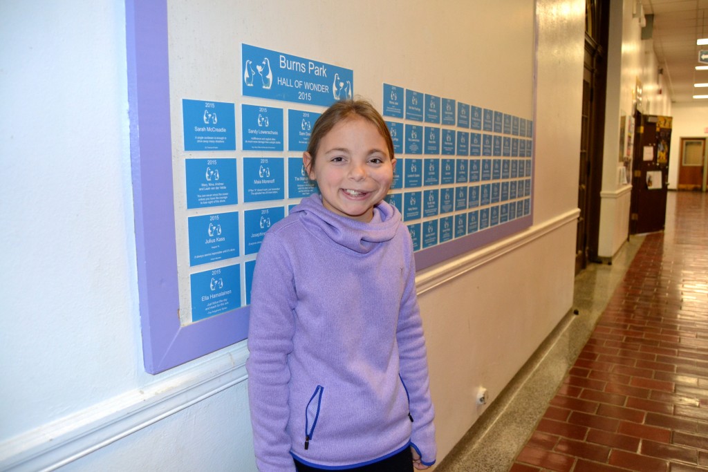 Hailey stands by the Wonder Wall at Burns Park Elementary