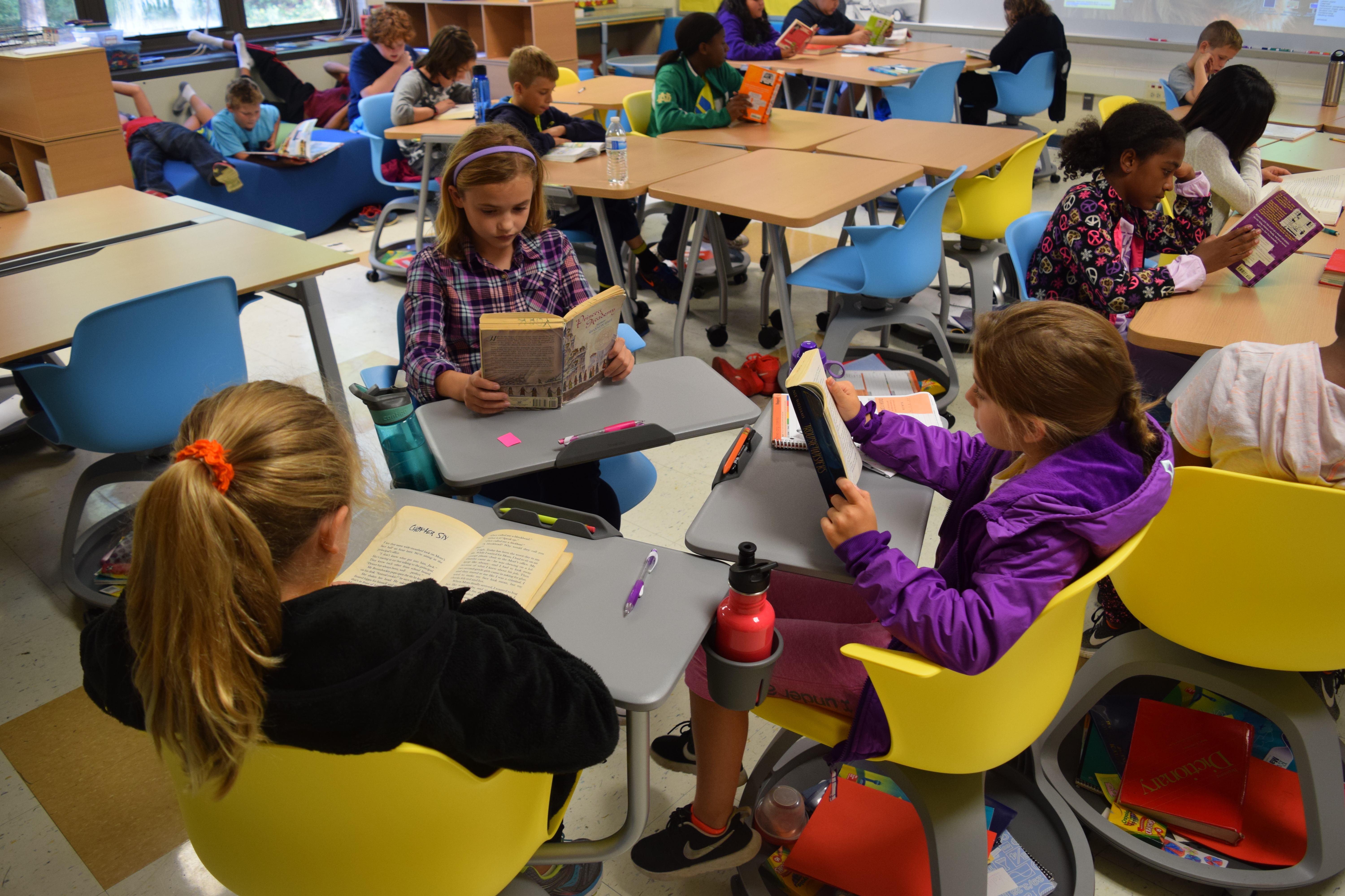 Three 5th grade girls read at new desks