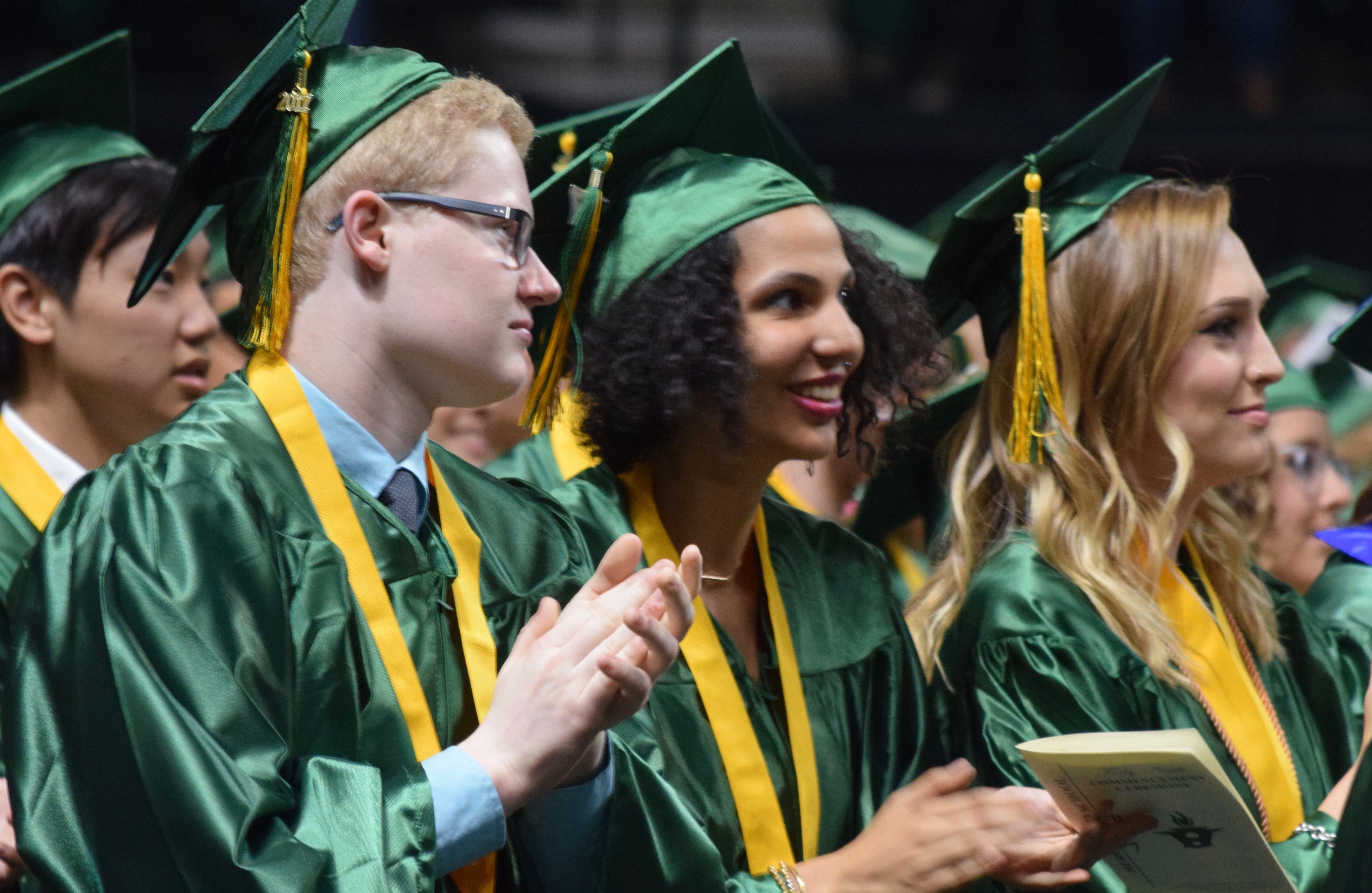 A group of Huron grads clap during the Commencement Address