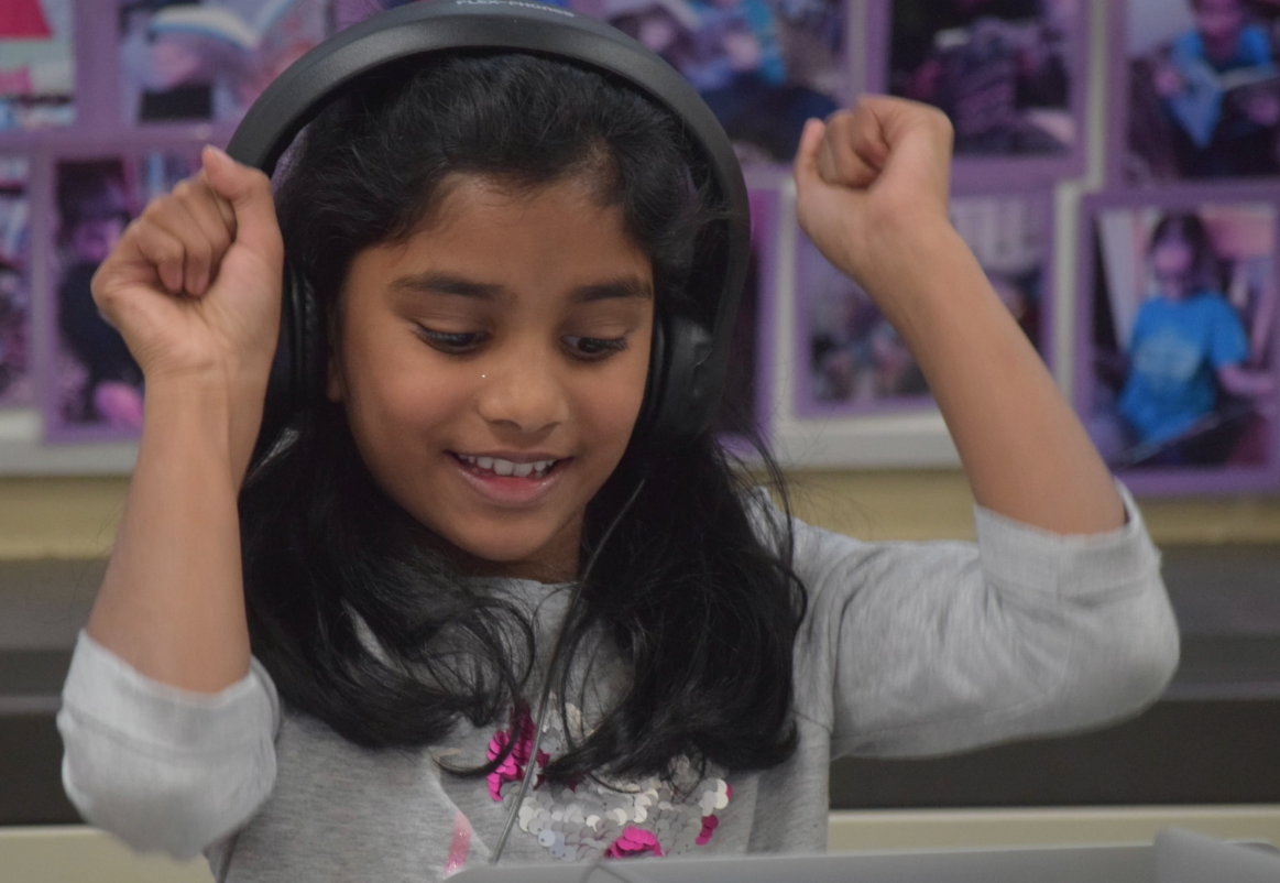 A Lakewood student celebrates as she has a coding success during an Hour of Code event