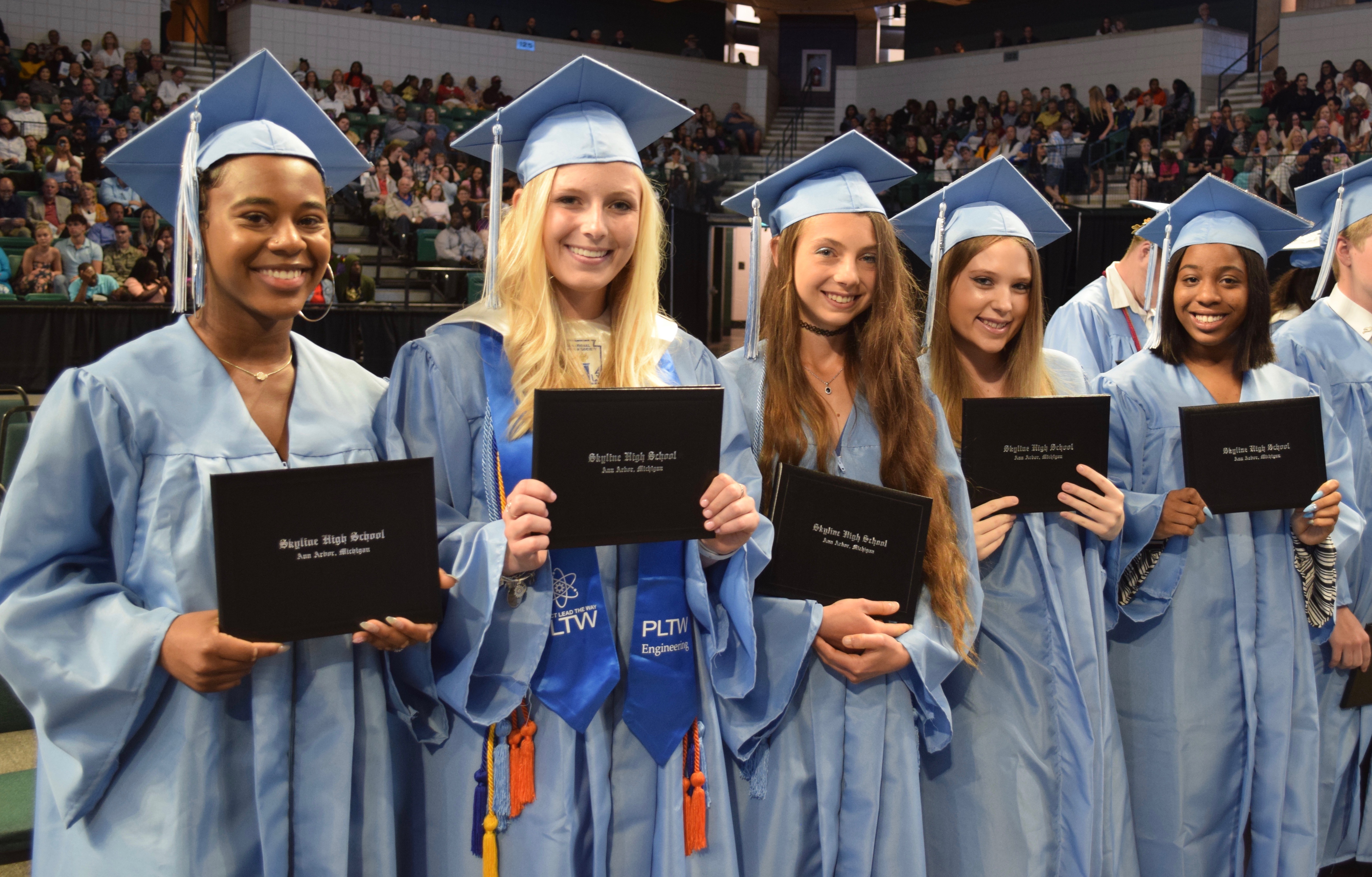 5 female members of the Skyline High School class of 2019 holding their diplomas at graduation