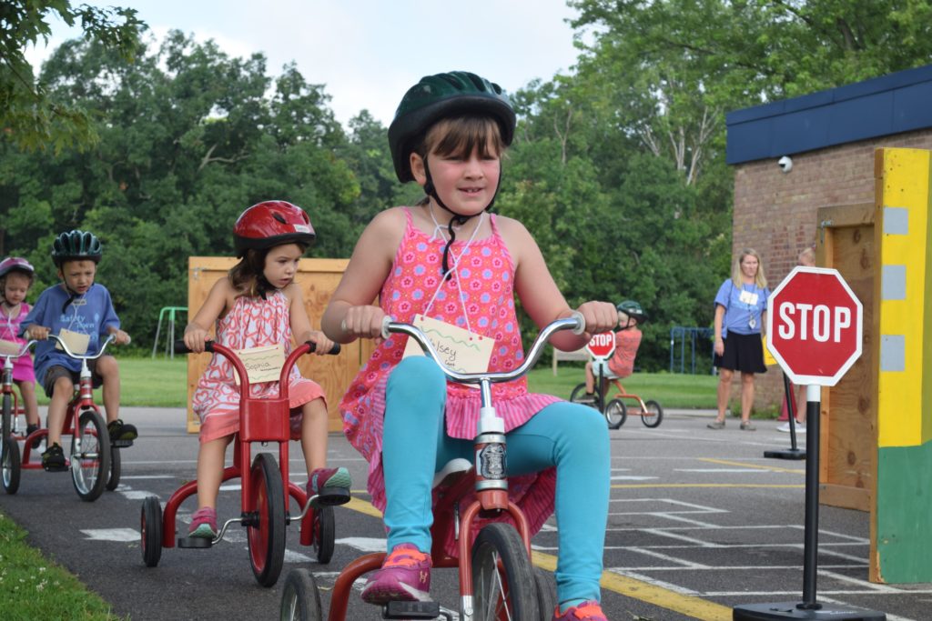 several young children riding tricycles in Safety Town
