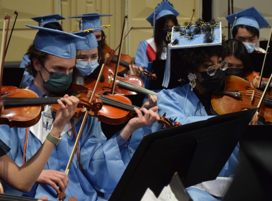 String musicians in their Skyline cap and gown playing their instruments