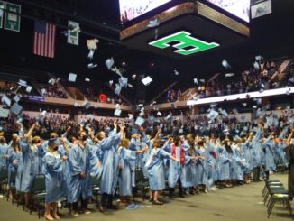 Skyline students toss their gaps into the air at the end of the commencement ceremony
