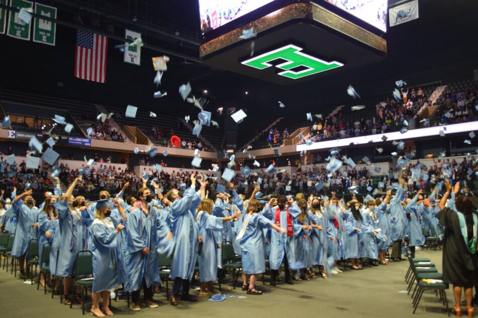 Skyline students toss their gaps into the air at the end of the commencement ceremony