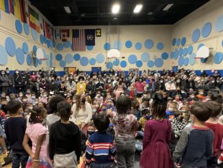 Students singing to a room full of parents