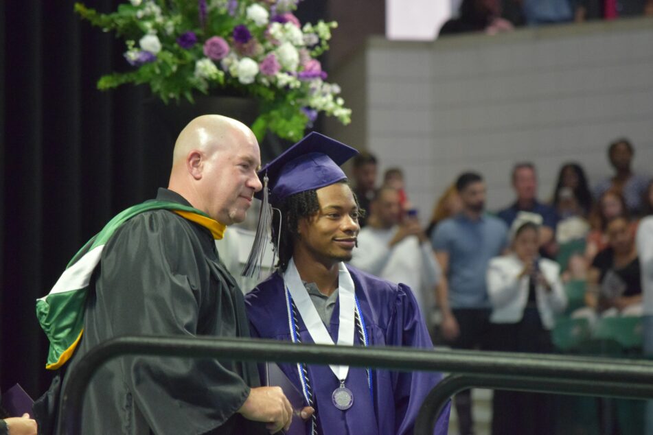 A male Pioneer student receives his diploma.