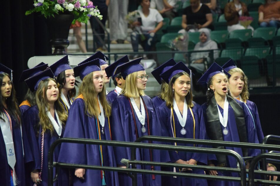 Pioneer students sing the alma mater after receiving their diplomas.