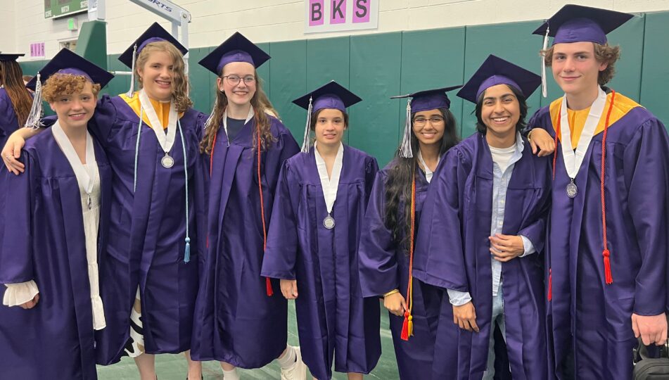 A group of Pioneer students in purple caps and gowns before the ceremony begins.