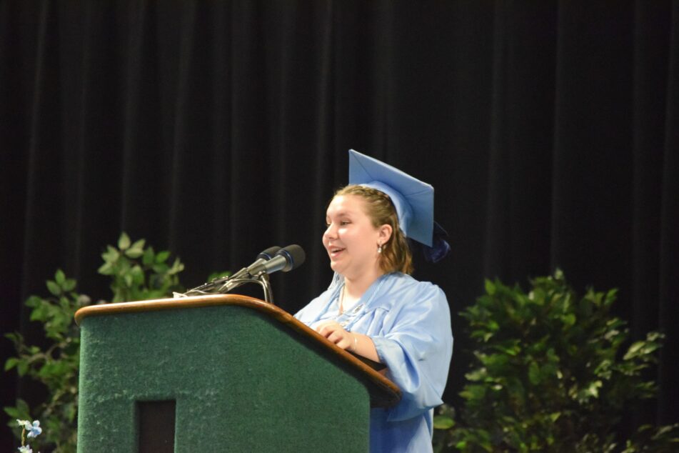 Skyline Student in cap and gown gives the student address at Commencement Ceremony.