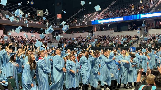 Skyline students toss their caps into the air in celebration after receiving their diplomas.