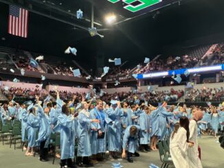Skyline grads throw their caps into the air as they celebrate.