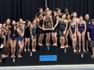 Pioneer girls swim and dive team with the trophy after winning their sixth straight MHSAA Division One State Championship at Oakland University.