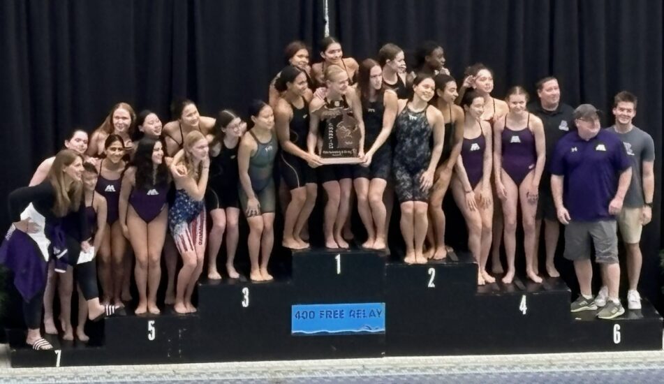 Pioneer girls swim and dive team with the trophy after winning their sixth straight MHSAA Division One State Championship at Oakland University