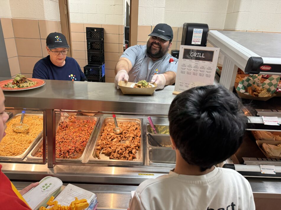 A server hands a student a chipotle lime chicken and brown rice bowl at Slauson