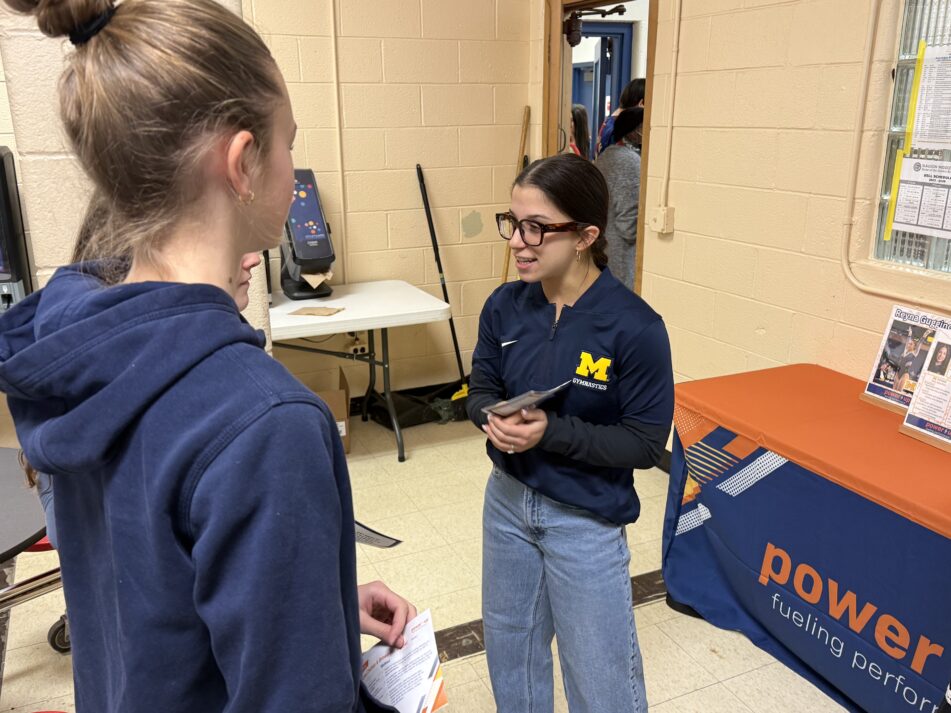 University of Michigan gymnast Reyna Guggino talks with some Slauson students.