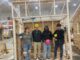 Four homebuilding students inside the structure they built together to demonstrate their skills and ability to work as a team.