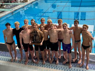 Pioneer Boys Swim and Dive team hold the state championship trophy on the pool deck.