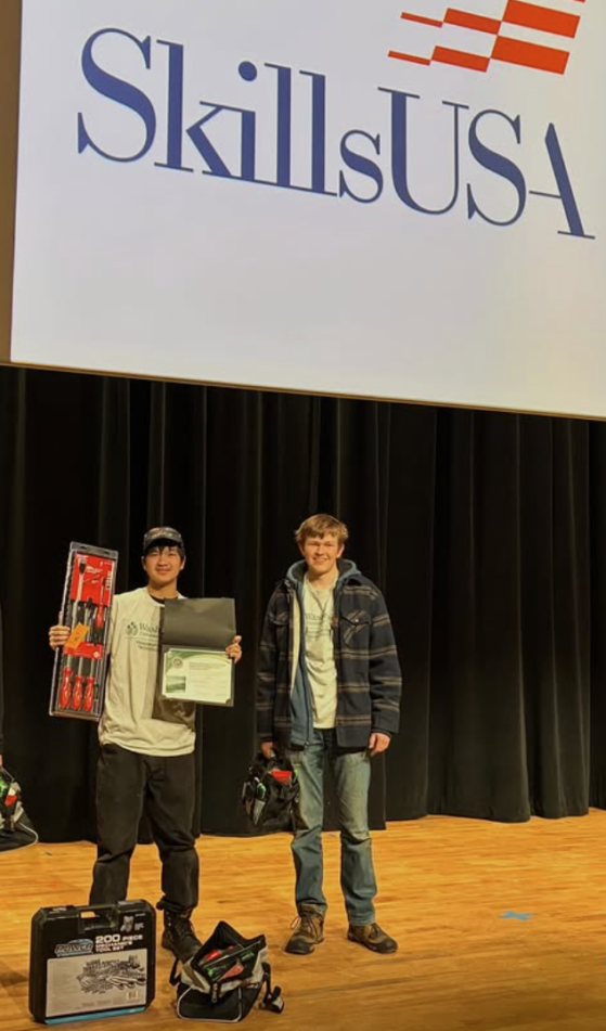 A pair of students on stage at the Skills USA regional after earning their spot to advance to the state competition.