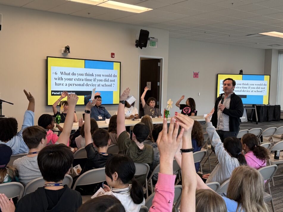 Students raise their hands at the Digital Wellness Expo in response to questions about appropriate technology use.