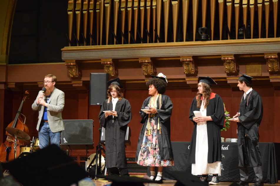Four Community grads on stage ready to give their speeches.