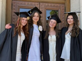 Four Community grads in caps and gowns outside before the ceremony.