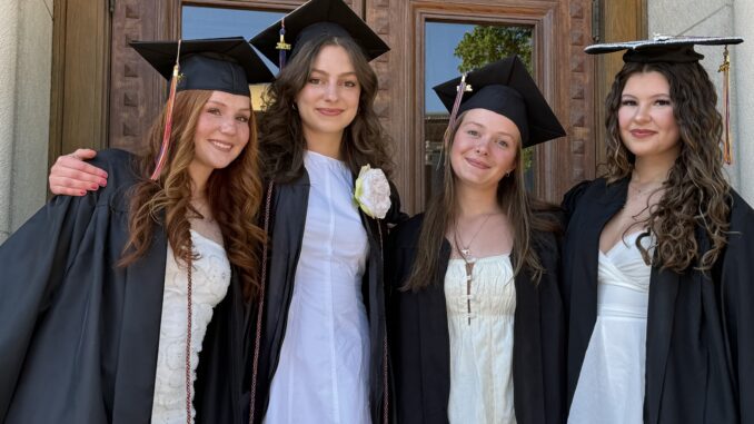 Four Community grads in caps and gowns outside before the ceremony.