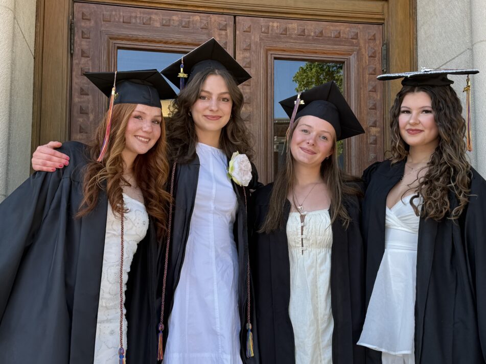Four Community grads in caps and gowns outside before the ceremony.