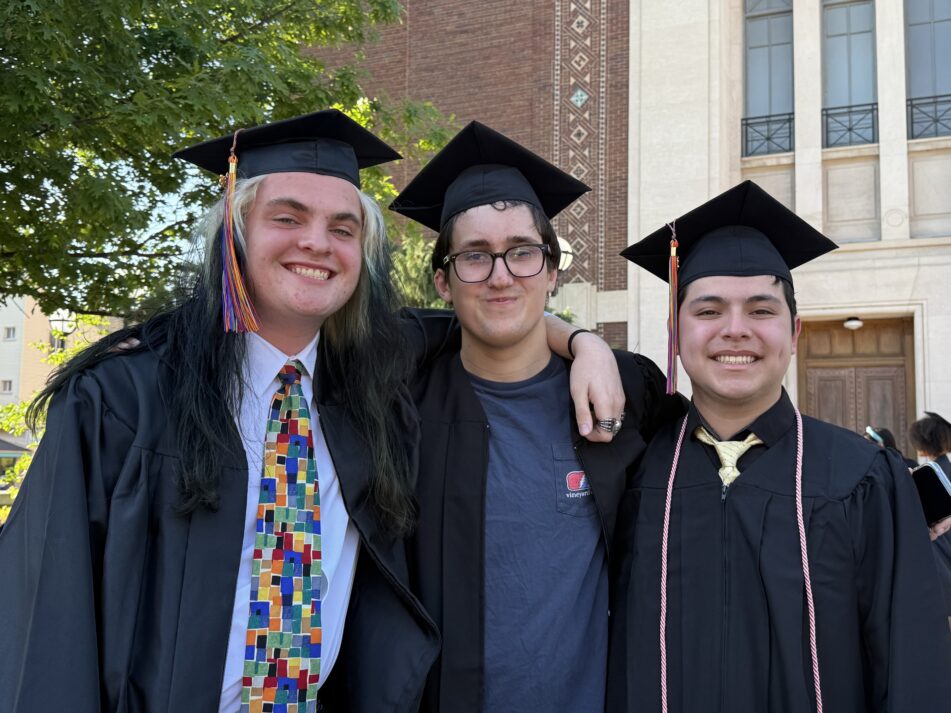 Three Community grads in caps and gowns outside before the ceremony.