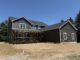A large house almost finished with some scaffolding still in front and the yard is still dirt