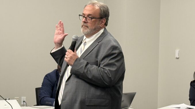 Steve Norton takes the oath of office after being picked to fill a vacancy on the Board of Education