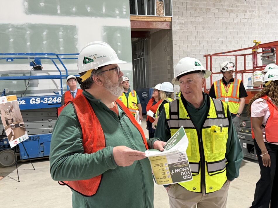 Board of Education Trustee Steven Norton and McCarthy and Smith Construction Services President Bill McCarthy discuss construction plans in what will be the cafeteria.