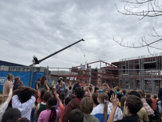 Dicken students and staff cheer as the last beam is placed in their new school