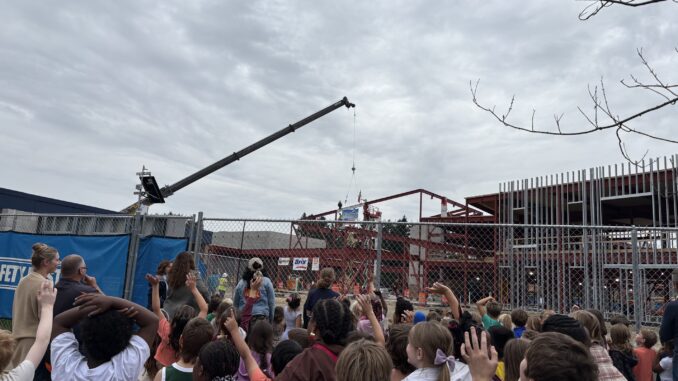 Dicken students and staff cheer as the last beam is placed in their new school