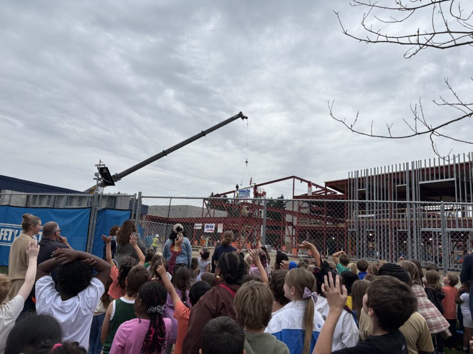 Dicken students and staff cheer as the last beam is placed in their new school
